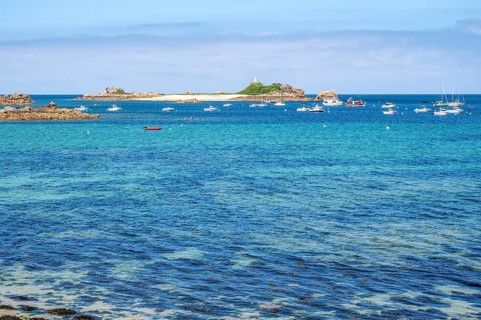 A large rock of pink granite shaped by wind and weather dominates the right foreground, while in