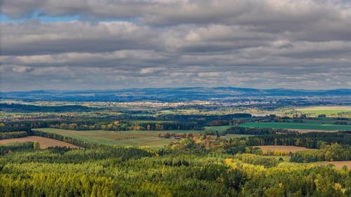 A wonderful view of an extensive green landscape in the Czech Republic during autumn. The clouds in