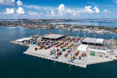 A busy port with shipping containers and cranes. Aerial view to new container unloading terminal of