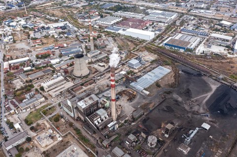 Factory complex with smokestacks amid an industrial urban setting. Aerial view of thermal power