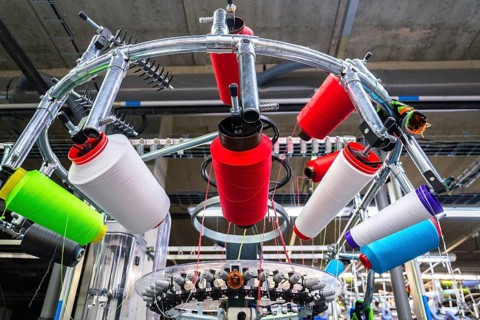 Colorful reel thread set up at modern and automatic sewing or embroidery spinning machine, textile