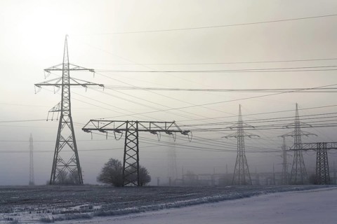 Electricity pylons from distribution power station in foggy winter freeze Prague Czech republic
