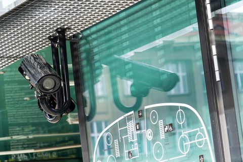 Security camera hanging down mounted on pole on the building facade Prague Czech republic