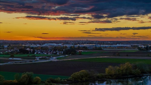 At sunset, the city of Straubing is painted in warm colors. The Danube flows calmly, while the