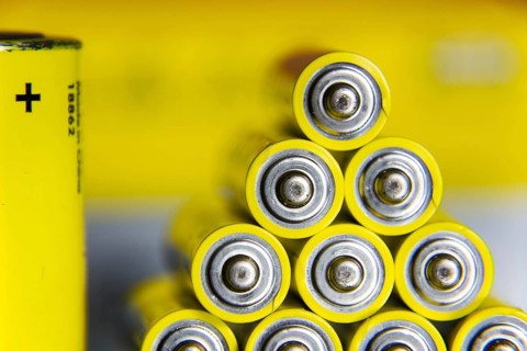 Stack of yellow AA batteries close up abstract coloured background Prague, Czech republic
