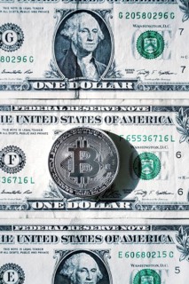 Silver bitcoin coin lying on United States dollars, cryptocurrency concept Prague Czech republic