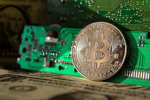 Silver bitcoin coin with dollars and computer motherboard, cryptocurrency mining and investing