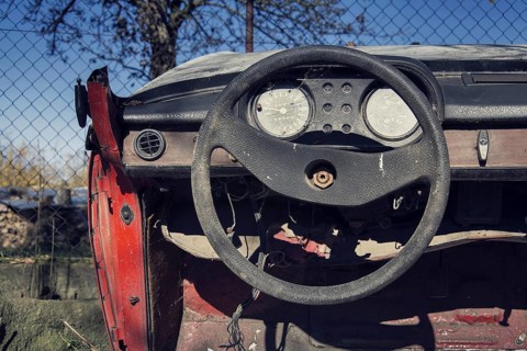 Filtered vintage photo of steering wheel and rusty speedometer on car control panel Prague Czech