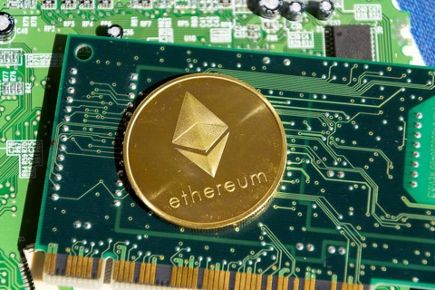 Golden ethereum coin lying on computer motherboard, cryptocurrency investing concept Prague, Czech