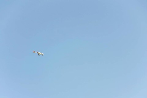 Unmanned aerial vehicle surveillance drone with light and camera flying, sunny summer day, drone