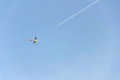 Unmanned aerial vehicle surveillance drone with light and camera flying, sunny summer day, drone