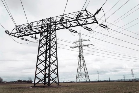 Electricity pylons conducting current from distribution power station, solar renewable energy and