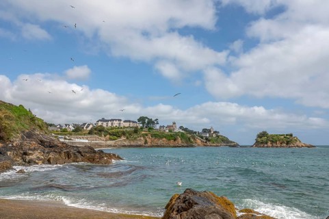 The rocky bay of the Plage de la Comtesse with turquoise water, bordered in the background by a