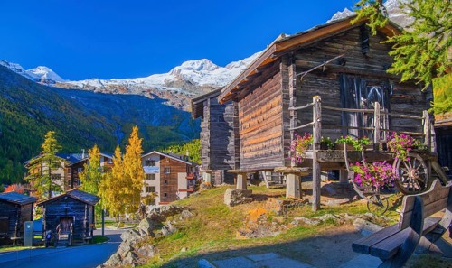 Typical granaries on the outskirts of the village with Allalin 4027m and Alphubel 4206m in autumn,