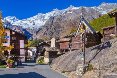 Saas wayside shrine with typical granaries on the outskirts of the village with Alphubel 4206m and