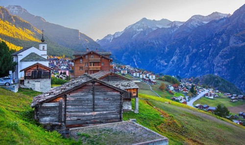 City overview on a mountain terrace above the valley with Ulrichshorn 3925 m after sunset, Grächen,