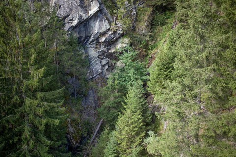 View of forest and rocks from the suspension bridge on the Sunnenseit'n-Weg hiking trail, in