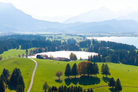 Hilly and wooded landscape with farm, Hegratsrieder See and mountains, near Füssen, Allgäu, Swabia,
