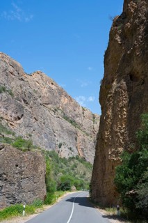 Asphalt road between high rock walls under clear sky, Amaghu Gorge from Noravank Monastery,