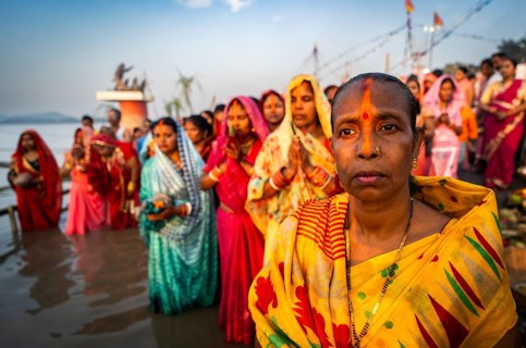 Hindu devotees offer prayers to the Sun God on the bank of Brahmaputra river on the occasion of