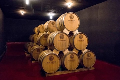 Many stacked wine barrels in a cellar with dim lights, Hin Areni Winery, Areni Village, Vayots Dzor