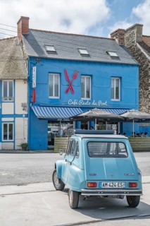 Parked sky blue Citroen 2CV with roll top in front of Café Resto du Port Le Surcouf, a popular