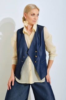 A fashion model poses confidently in a navy vest and light blouse. The background is bright and