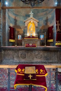 The altar with a variety of religious symbols and candles on decorated textiles, Khor Virap