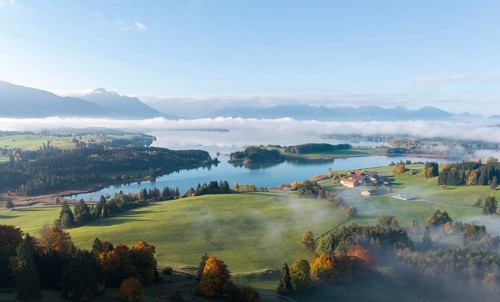 Wide landscape with Forggensee and mountains in the background, fog creates a quiet atmosphere,