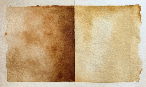 Two pieces of paper with a brownish color. The paper is folded in half and has a rough texture. AI