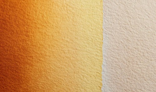 A tan and gold wall with a slightly darker shade of tan. The wall appears to be made of a textured