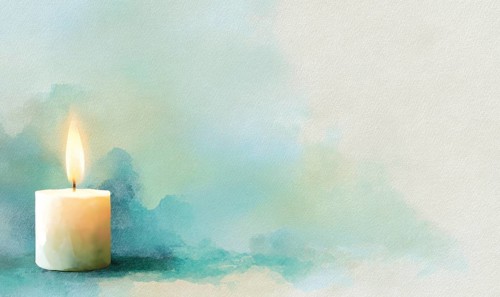 A candle is lit on a table in front of a blue background. The candle is the main focus of the