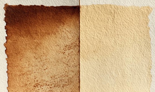 Two pieces of paper, one of which is brown and the other is white. The brown paper has a rough