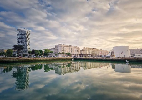 Beautiful waterfront scene in Le Havre, France at sunset. Buildings are perfectly reflected in the