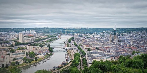 Panoramic view of the Rouen city in France, with the winding Seine river and numerous bridges.