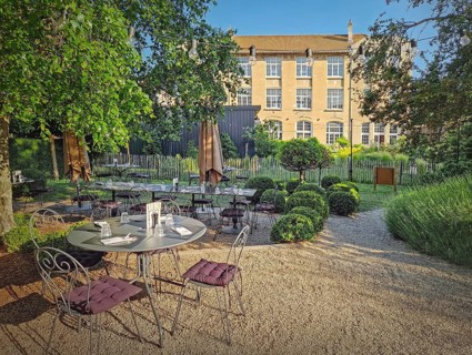 Rustic outdoor restaurant terrace with a classic, european garden aesthetic. The seating area
