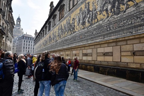 Dresden, Gerrmany- May 6, 2017: Tourist looking at the panel Procession of Princes the first of the