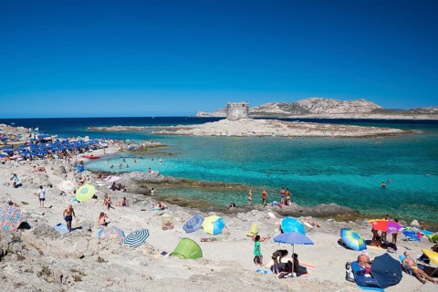 STINTINO, ITALY - AUGUST 21, 2017 - Unidentified people in the sun on the famous La Pelosa Beach on