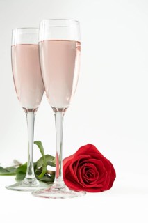 Two glasses of champagne and a red rose isolated on a white background