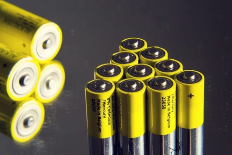 Yellow double A batteries reflecting in mirror, electricity storage concept Prague, Czech republic