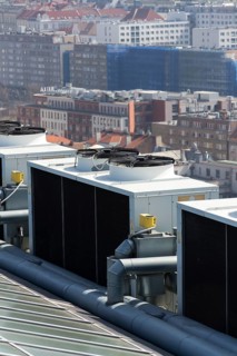 Air conditioning ventilators on roof with houses in background Prague Czech republic