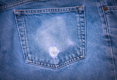 A Worn and tattered blue Jeans pocket