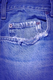 A Worn and tattered blue Jeans pocket