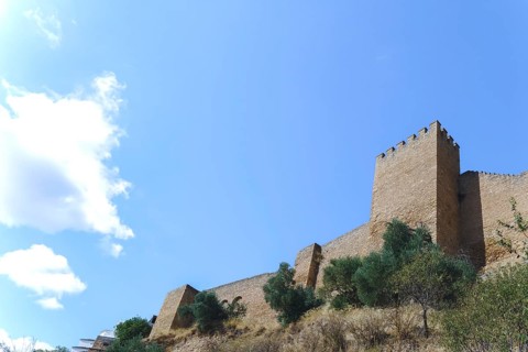 Ronda, malaga, spain Stone fortress wall and battlement under a bright blue sky, showing