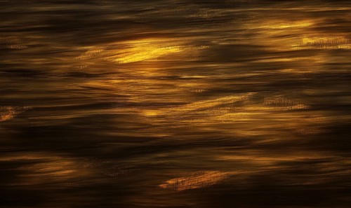 The image is of a body of water with a brownish hue. The water appears to be rippling and has a