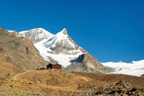 Snow-Capped Mountains and Mountain Hut on Sunny Day. Swiss Alps. Valais, Switzerland