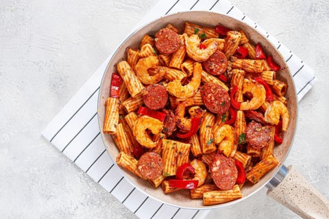 Jambalaya pasta with shrimp and sausages, cooked with bell pepper in a frying pan, homemade, on a