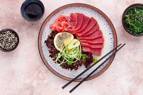 Freshly prepared sashimi with vibrant garnishes served on a decorative plate