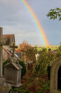 Rainbow over the heritage-protected cemetery near St. Marien Church, Lüdersen mountain village,