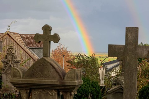Rainbow over the heritage-protected cemetery near St. Marien Church, Lüdersen mountain village,